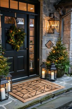 christmas wreaths and lanterns on the front steps of a house with two lit candles