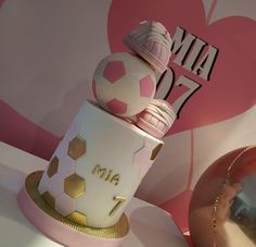 a pink and white cake sitting on top of a table next to a red heart