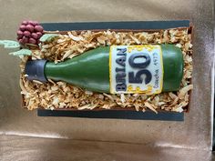 a cake made to look like a wine bottle in a box filled with wood shavings