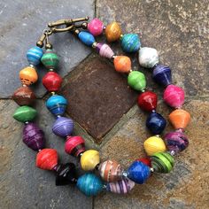 a multicolored beaded bracelet on a stone surface