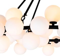 a chandelier with many white balls hanging from it's black metal arms