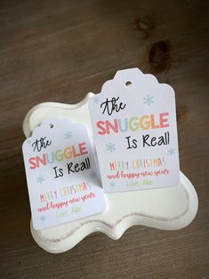 two tags that say the snuggle is real and merry christmas