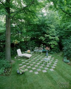 a garden with lawn furniture and trees in the background