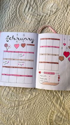 an open planner book on a bed with hearts and stars in the pages that read,'february '