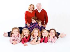 an older man and two women posing with their children for a family photo in front of a white background