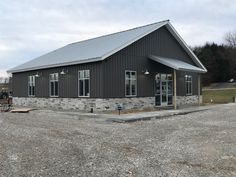 a large gray building sitting on top of a gravel lot