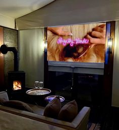 a living room filled with furniture and a flat screen tv mounted on the wall next to a fire place