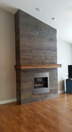 an empty living room with wood floors and a fireplace