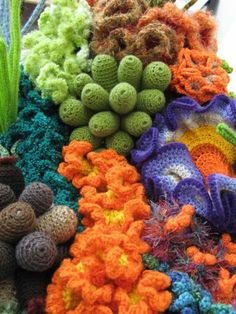 there are many different crocheted items on display in this photo, including balls and flowers