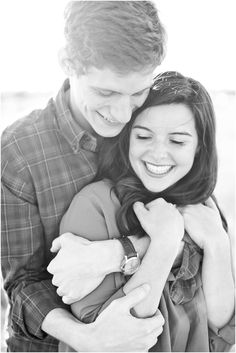 a man and woman hugging each other in black and white