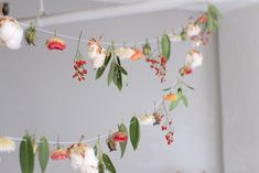 flowers and leaves are hanging from a string