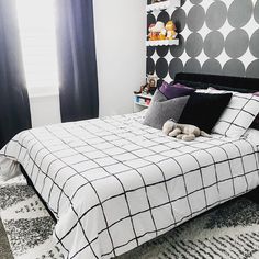 a bedroom with black and white decor on the headboard, bedding, and rugs