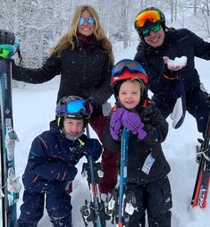 a group of people standing next to each other in the snow with skis on