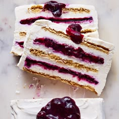 two slices of cake with white frosting and cherries