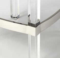 a glass and chrome table with two legs on it's side, against a white background