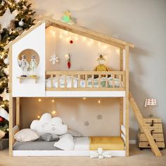 a wooden bunk bed sitting next to a christmas tree in a room with lights on it