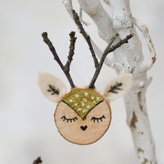 an ornament made to look like a deer's head hanging from a tree branch