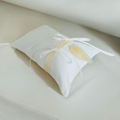 a white pillow with a yellow ribbon tied around it