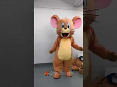 a person in a mouse costume standing next to a stuffed animal