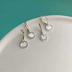 Perfect for the minimalist ... these handmade, tiny silver earrings are the absolute sweetest!  The dainty dangles are super-minimal and feminine with just a 1/3" diameter drop.  The secure, leverback earwires ensure your earrings will stay put and lightweight (but never flimsy) dangles are comfortable all day long. 100% STERLING SILVER OVERALL SIZE  The dangle on these earrings are VERY TINY and measure just 3/4" overall. Please scroll through all listing photos and video to gauge in-real-life size as photos are enlarged to show detail. CENTER COIN FINISH Handmade to order: You may choose the center coin to be brushed with a satin finish or hammered with a glossy finish. The outer ring is lightly hammered and glossy. EARWIRE STYLE  Secure, leverback earwires. SHIPPING  Ships free from Nor Minimalist Nickel-free Drop Cartilage Earrings, Dainty Nickel-free Sterling Silver Huggie Earrings, Dainty Sterling Silver Nickel-free Huggie Earrings, Minimalist Dangle Cartilage Earrings, Tiny Minimalist Drop Earrings, Dainty White Sterling Silver Huggie Earrings, Dainty Silver Nickel-free Huggie Earrings, Tiny Silver Huggie Earrings, Dainty Sterling Silver Huggie Earrings For Everyday