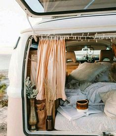 the back of an open van with pillows and blankets in it