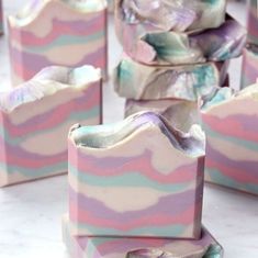 soap bars with pastel swirls on them sitting on a white countertop in front of each other