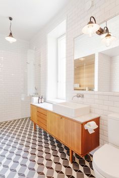 a bathroom with black and white floor tiles