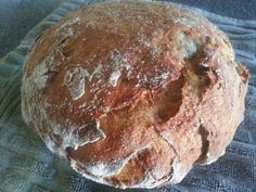 a round loaf of bread sitting on top of a blue cloth covered in powdered sugar