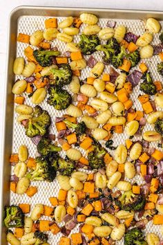 broccoli, carrots, and other vegetables on a baking sheet in a pan