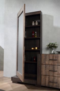 an open wooden cabinet with drawers and mirrors on it's sides, in front of a white wall