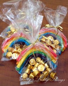 small bags filled with candy and gold coins on top of a wooden table next to each other