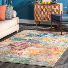 a living room area with blue walls and colorful rugs on the hardwood flooring