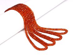 an orange strand of beads on a white surface