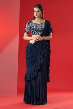 Navy blue pre-draped saree with ruffled panels. Paired with hand embroidered blouse with floral and geometric motifs.
Component: 2
Pattern: Embroidered
Type Of Work: Floral,geometric
Neckline: Sweetheart
Sleeve Type: Short
Fabric: Georgette crepe and satin
Color: Blue
Other Details: 
Closure: Back hook opening
Ruffle saree
Floral,geometric motifs
Occasion: Sangeet - Aza Fashions Hand Embroidered Blouse, Draped Saree, Saree Floral, Ruffle Saree, Drape Saree, Desi Style, Blue Saree, Floral Geometric, Geometric Motifs