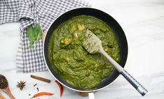 a pan filled with green sauce next to spices