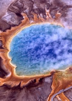 an aerial view of a blue crater in the desert