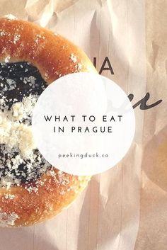 a bagel covered in powdered sugar with the words what to eat in prague