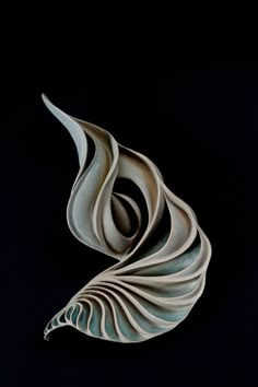 an abstract sculpture made out of white paper on a black background with the shape of a wave