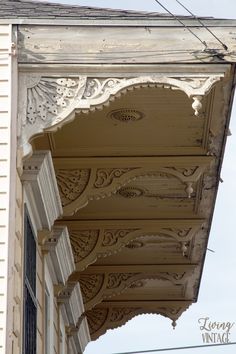 an ornately decorated porch on the side of a house with blue skies in the background