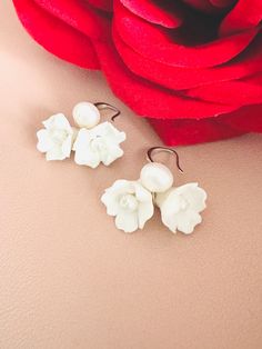 Skillfully crafted by hand, each earring showcases two delicate white clay flowers adorned with freshwater pearls. These exquisitely made flower bridal earrings are a perfect choice for your special day. 🖤 M A T E R I A L S  *  A N D  *  S I Z E  🖤 ❇️ MATERIAL & METAL: Brass- Clay Flower/Freshwater Pearl/Cubic Zirconia ❇️ METAL PLATING: Silver/Gold/Rose Gold ❇️ ESTIMATED SIZE: 3cm Length (Included Finish Post) ❇️ ESTIMATED WEIGHT: 8gram ❇️ QUANTITY: 1pair ❇️ LEAD-FREE & NICKEL FREE 🖤 A V A I L A B L E  *  F I N I S H 🖤 ❇️#1-CZ HOOP ❇️#2-CRYSTAL POST ❇️#3-PLAIN FISH HOOK ❇️#4-TEXTURE FISH HOOK ❇️#5-CLIP ON ❇️#6-PLAIN HOOP ❇️#7-CZ FISH HOOK ❇️#8-CZ FISH HOOK 🖤 C U S T O M I Z I N G  *  A N  *  E X I S T I N G  *  P I E C E 🖤 If you love this piece but feel you would like to make a few Adjustable White Jewelry With Flower Decoration, White Flower Shape Jewelry For Anniversary, White Flower-shaped Anniversary Jewelry, Delicate Adjustable Earrings For Wedding, Delicate Adjustable Wedding Earrings, Formal White Flower Earrings, Flower-shaped Earrings For Wedding Gift, Flower-shaped Pearl Drop Jewelry For Anniversary, Adjustable Pearl White Flower-shaped Jewelry