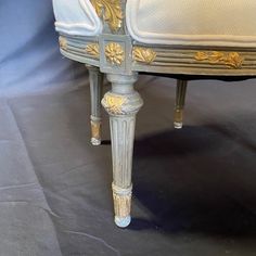 an ornately decorated bed with gold trimmings on the headboard and foot board