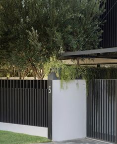 a black and white fence next to a tree