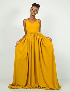 Long, elegant, and stunning, Hornet is the dress you want to be wearing when you show up to that summer event. You will turn heads. Oh! You will turn heads. In fact, you might even break a few necks (poor necks 😊) It is made from polyester fabric. It features a Vneck at the front and a Criss-cross rope pattern at the back. You can request a closed back in the Personalization text box below. The dress has pockets on both sides. The dress is 64 inches long. The length can be adjusted on request. The model is wearing a UK 6/XS. She is 5'6/ 168 cm. Colour: Mustard Mustard Wedding Dresses, Outfit Palette, Mustard Yellow Dress, Fashion Costume Halloween, Mehndi Outfits, Mustard Yellow Dresses, Rope Pattern, African Wear Dresses, Country Dresses