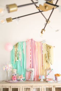 a room with many different colored ribbons on the wall and decorations hanging from the ceiling