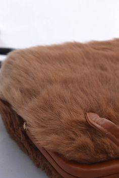 What a pretty vintage handbag, its covered in soft brown fur, with a contrasting strip of cream fur! This purse has two pockets inside, one zippered and one open. A deep caramel color trims the bag and handles. What a great gift! It would be wonderful with a vintage outfit, or just jeans and a white shirt! This handbag measures 9 inches high, 9 inches across, and about 3 inches wide, with the two interior pockets. There is no label inside. The handles have a 5 inch drop. For more lovely vintage Brown Rectangular Bag With Faux Fur Lining, Brown Shoulder Bag With Faux Fur Lining, Brown Faux Fur Lined Shoulder Bag, Brown Bags With Plush Lining For Winter, Brown Winter Bags With Plush Lining, Winter Brown Bags With Plush Lining, Brown Faux Fur Lined Tote Shoulder Bag, Brown Winter Shoulder Bag With Faux Fur Lining, Brown Shoulder Bag With Faux Fur Lining For Winter