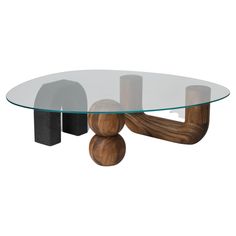 an oval glass table with wooden legs and two small rocks on the bottom, sitting in front of a white background