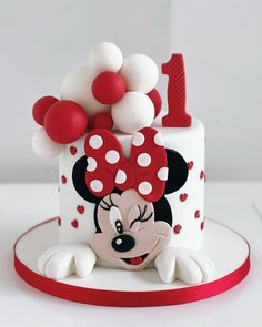 a minnie mouse cake with red and white decorations