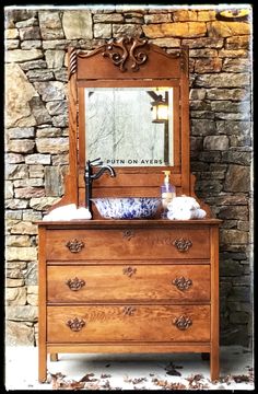 a wooden dresser with a mirror and soap dispenser in front of it