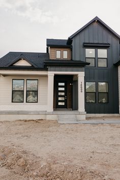 a house that is in the middle of some dirt and sand with no grass around it