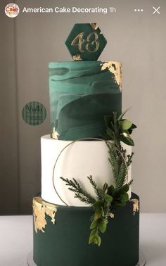 a three tiered cake with green and gold decorations